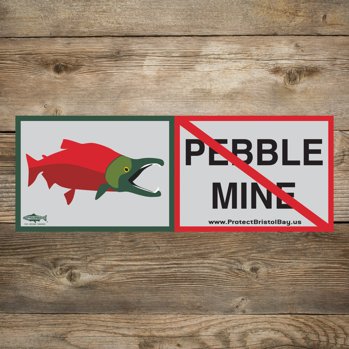 A wood background has a sticker that has a sockeye salmon on one side and the words pebble mine crossed out on the other side. The website www.protectbristolbay.us is written and a logo that says repyourwater inside a trout silhouette with the words fish
