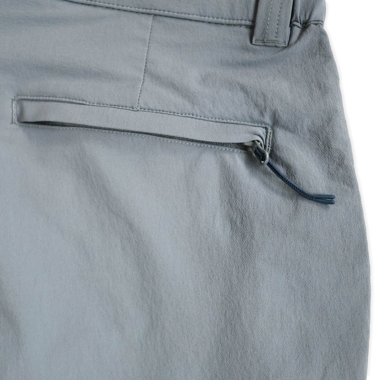 Close-up of light blue pants pocket with a zipper pocket on a white background