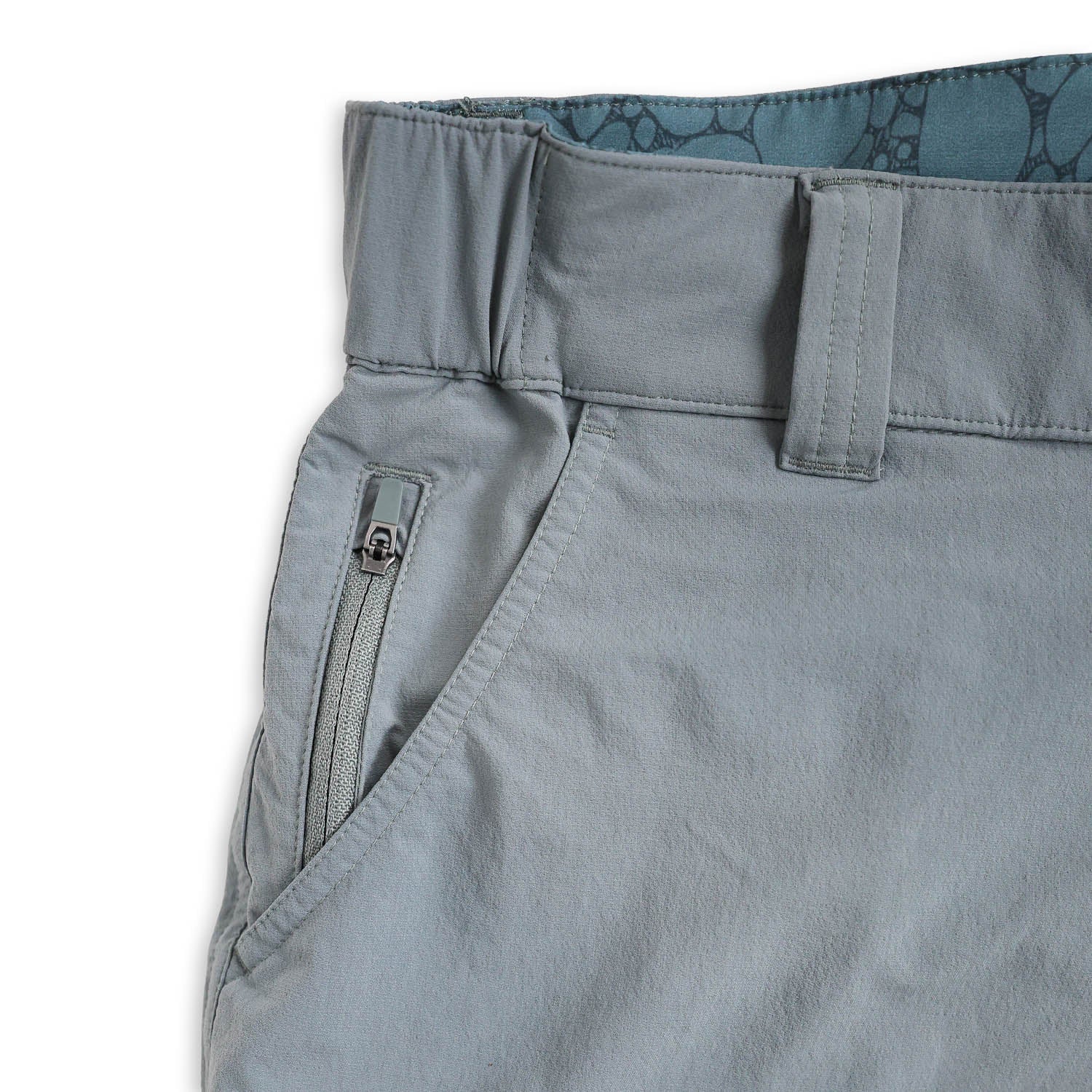 Close-up of light bluepants with a zipper and patterned lining on a white background