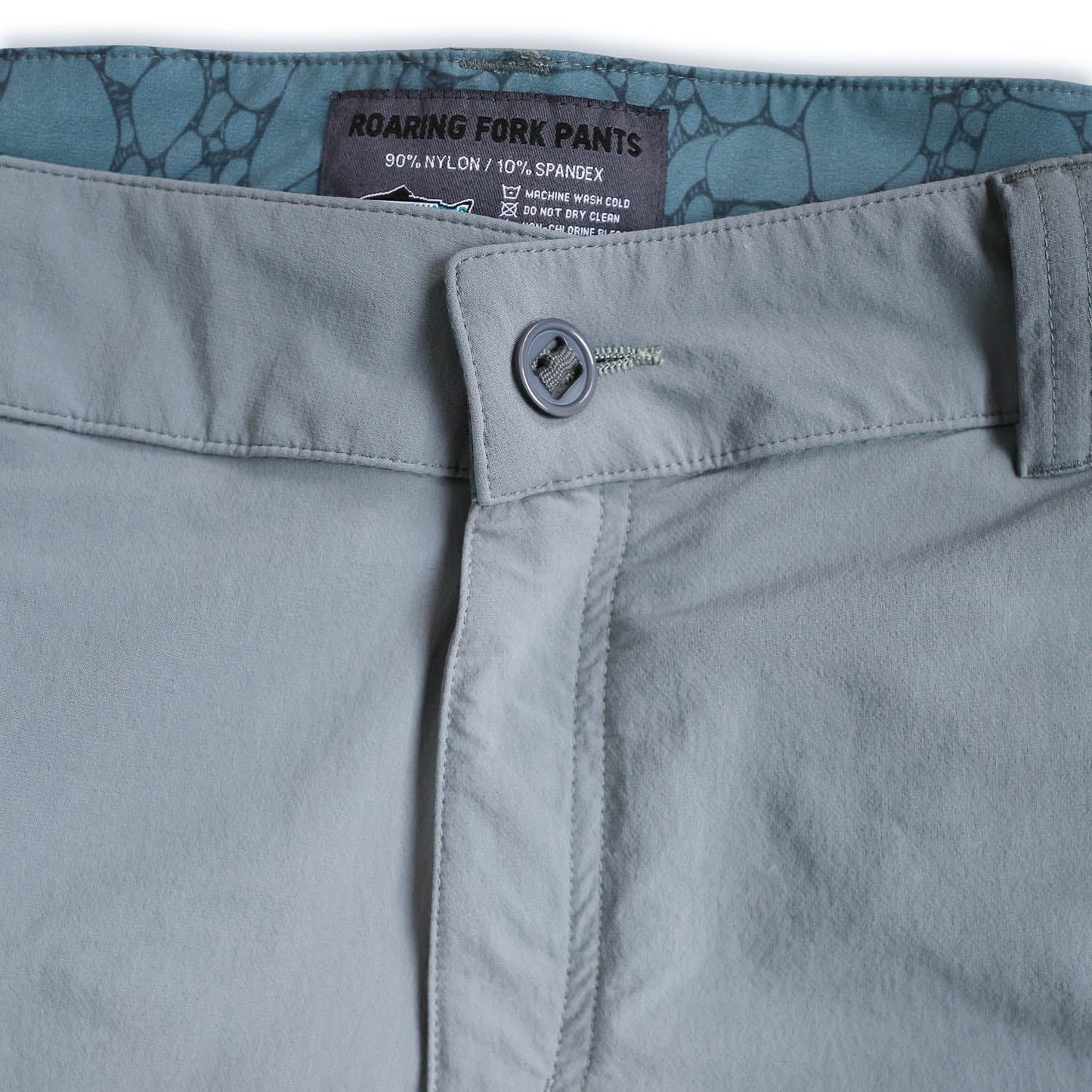 Close-up of light bluepants with a brand label on a white background