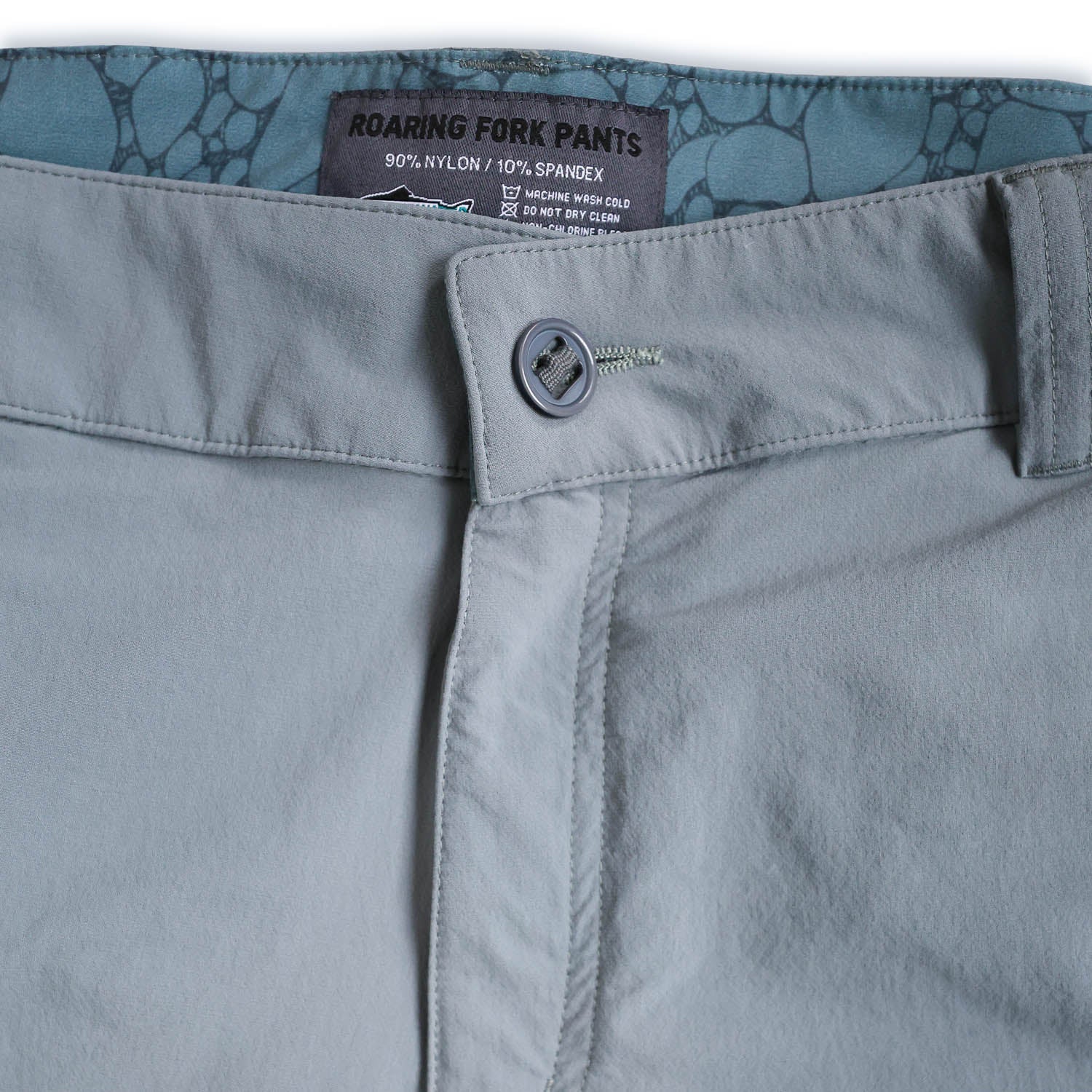 Close-up of light bluepants with a brand label on a white background