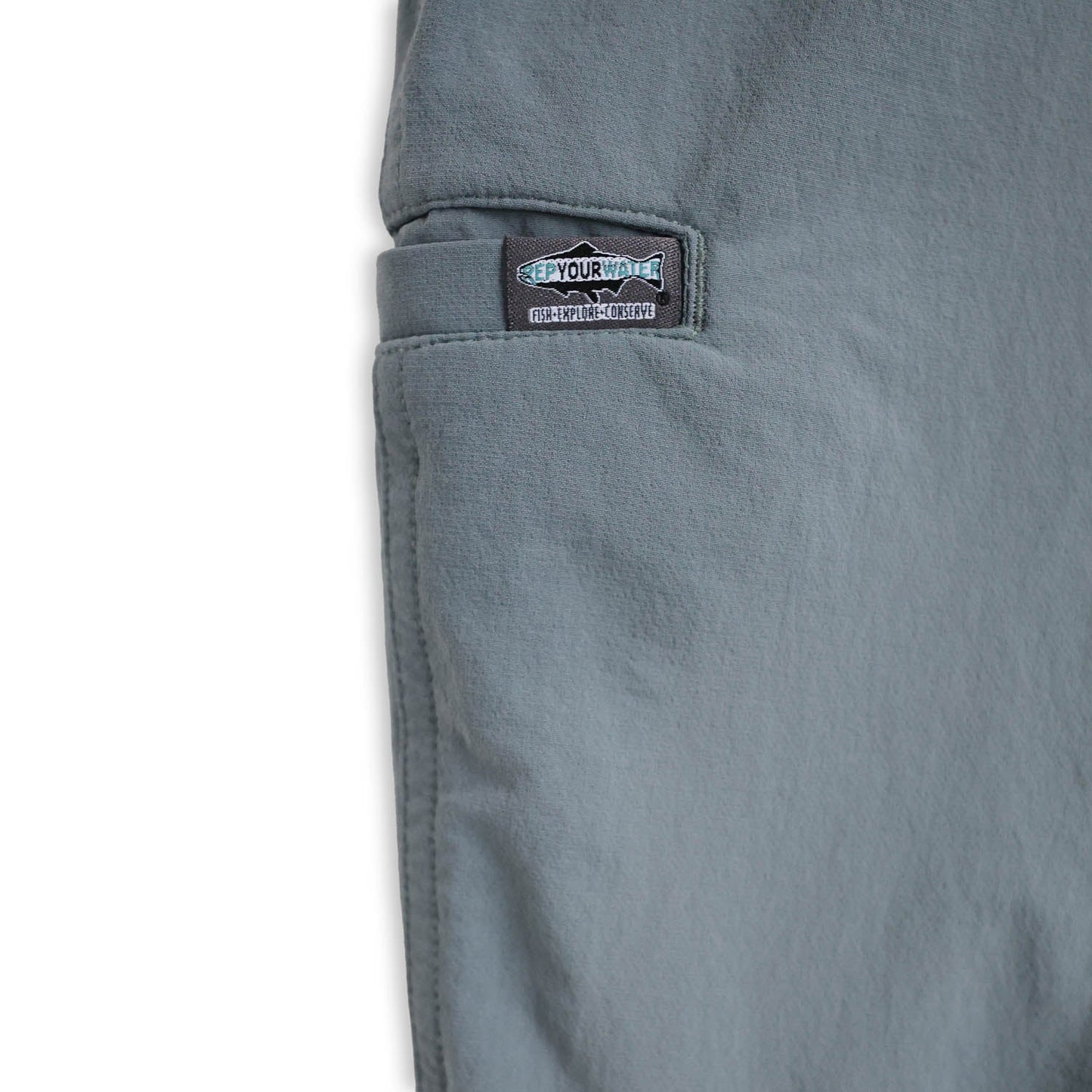 Close-up of a light blue pants pocket with a brand label on a white background