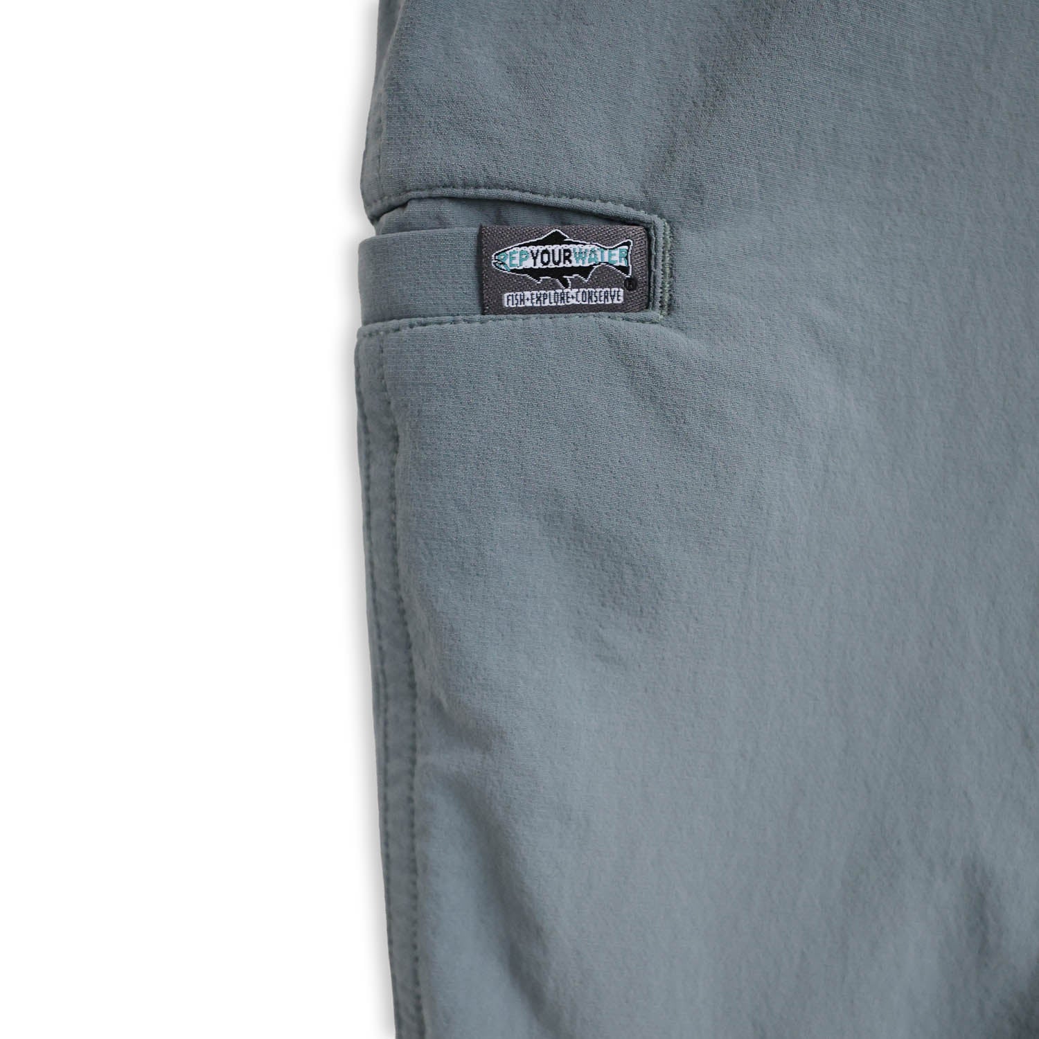 Close-up of a light blue pants pocket with a brand label on a white background