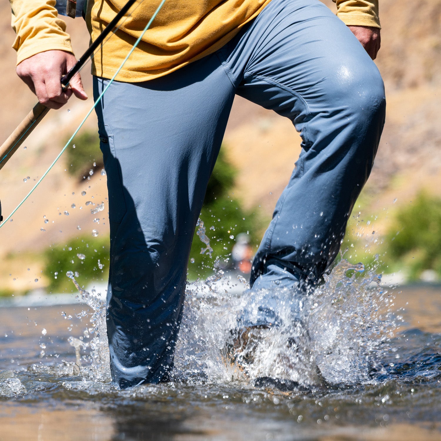 MAn walking through water splashing in blue pants